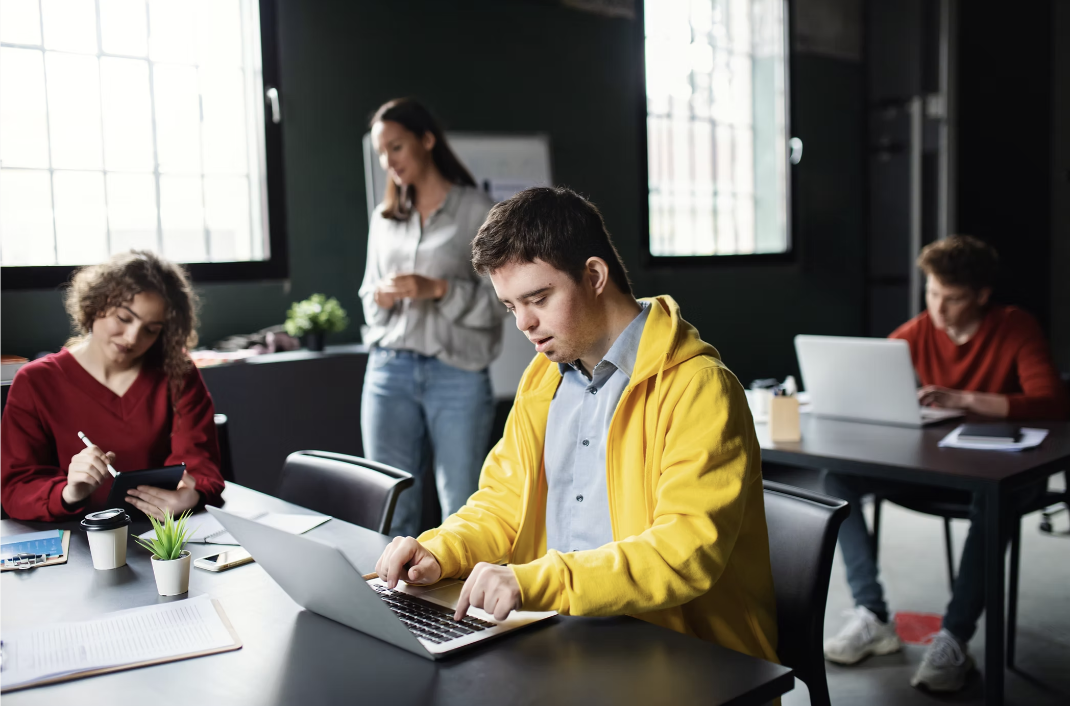 People working in a shared learning space with laptops and notes